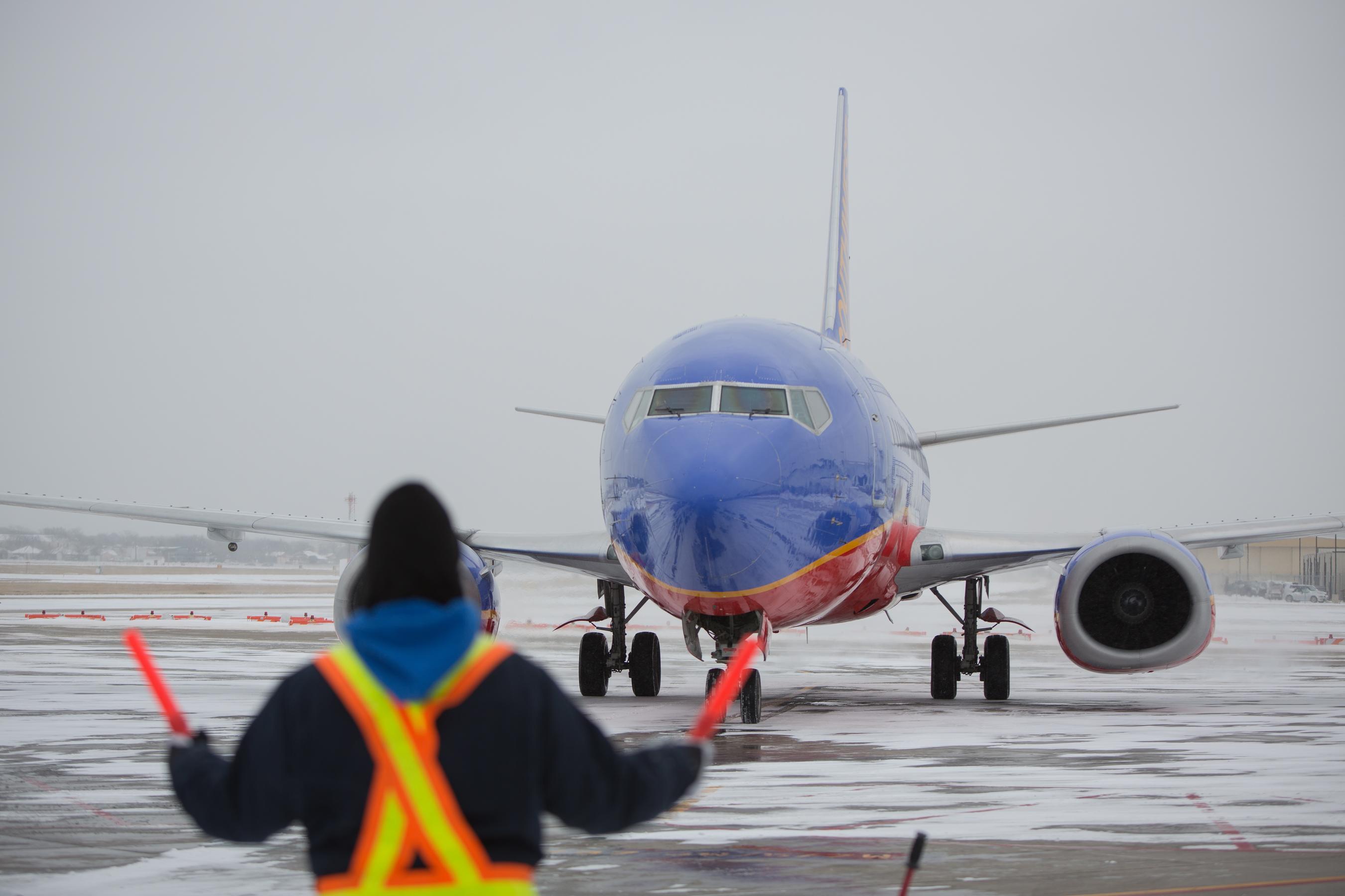 Southwest Airlines employees work through the snow at Dallas Lov